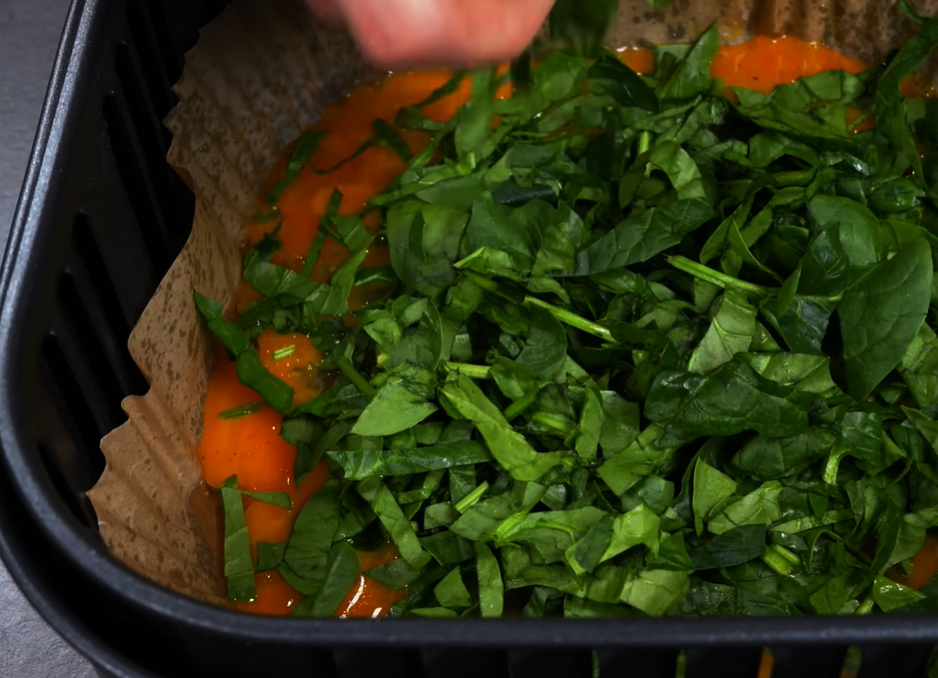 Verteile den frischen Spinat gleichmäßig über den Eiern.