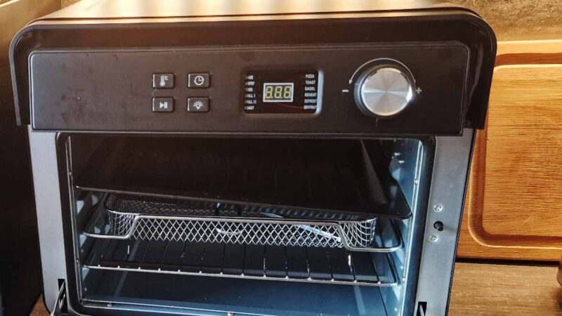Schwarze Caso AirFry Chef 1700 Heißluftfritteuse mit Glastür und Drehknopf auf einer Küchenarbeitsplatte